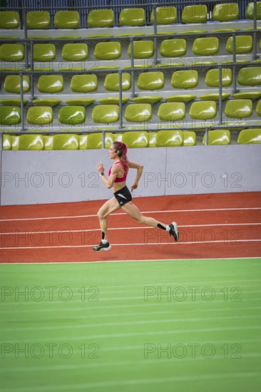Female athlete running at high speed in an indoor sports hall, middle distance runner Katharina
