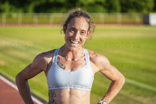 Sportswoman with happy expression on the track after training, radiates satisfaction, middle