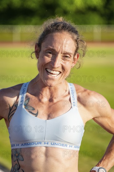 Close-up of laughing woman in sportswear with tattoos, middle distance runner Katharina Jaiser,