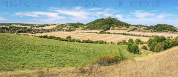 View over hilly landscape with meadows, fields and forests of Wachsenburg Castle and the village of