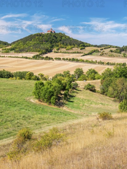 View of hilly landscape with meadows, fields and forests of Wachsenburg Castle in summer,