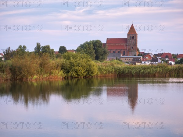 Tribsee with St. Thomas Church in the evening, reflection in a lake, North German brick Gothic,