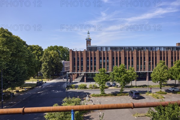 Rheinhallen exhibition halls, brick buildings, aboveground district heating pipeline, parking lot