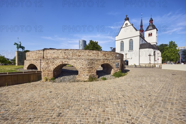 Historic railway hub, Alt St. Heribert church, equestrian statue, cobblestone walkway, lawn, trees,