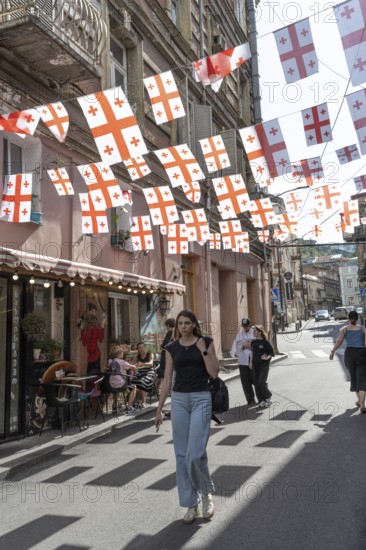 Tbilisi, Georgia. July 7th 2025. Georgian flags flutter over a side street in the Old Town in
