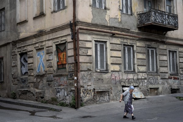 Tbilisi, Georgia. July 15th 2025. An elderly Georgian lady crossing the street in the downtown