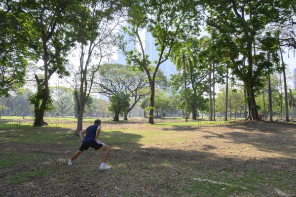 Bangkok, Thailand. March 4th 2025. A local man does some warm up stretches and exercises to keep