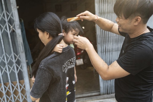 Bangkok, Thailand. March 18th 2025. A local family outside their shop house in the streets of Talat
