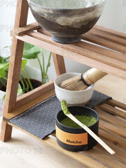 Matcha powder in a scoop with whisk and bowl ready for a traditional tea ceremony