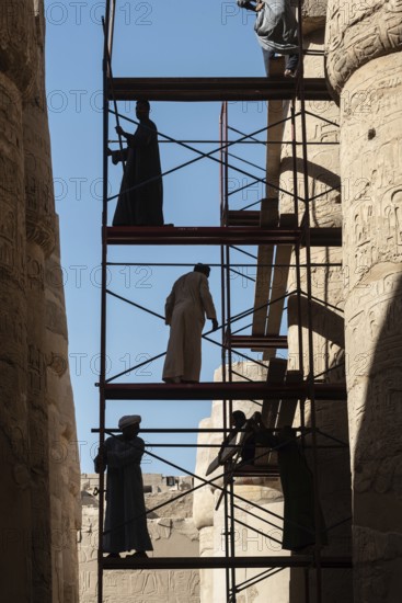 Luxor, Egypt. December 12th 2022 Silhouetted local Egyptian workers cleaning and restoring the