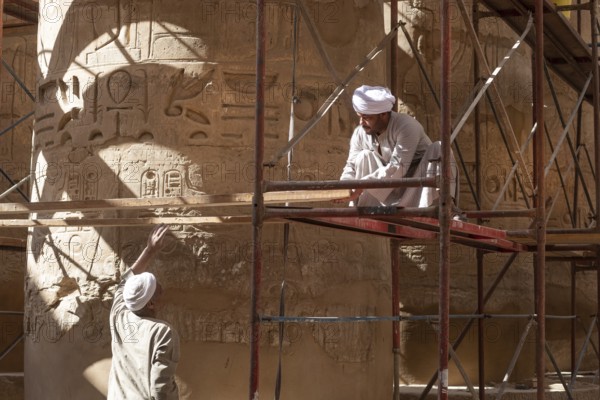 Luxor, Egypt. December 12th 2022 Local Egyptian workers cleaning and restoring the ancient columns
