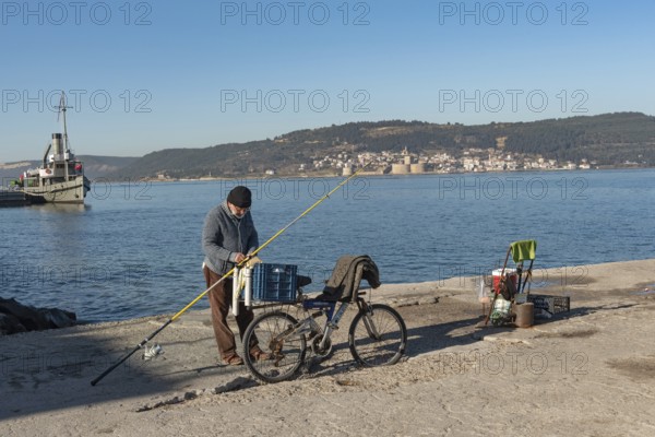 Canakkale, Turkey. February 18th 2022 A Turkish fisherman on the pier at Canakkale, with the