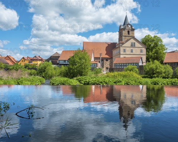 View across the Werra river to the small village of Themar with church and half-timbered houses,
