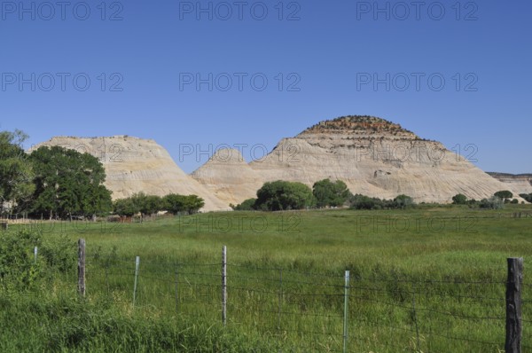 Green meadow with view of rocky mountains under clear sky, Grand Staircase Escalante National