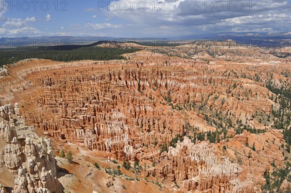 Wide rocky landscape under cloudy sky with orange canyons, Bryce Canyon National Park, Utah, USA