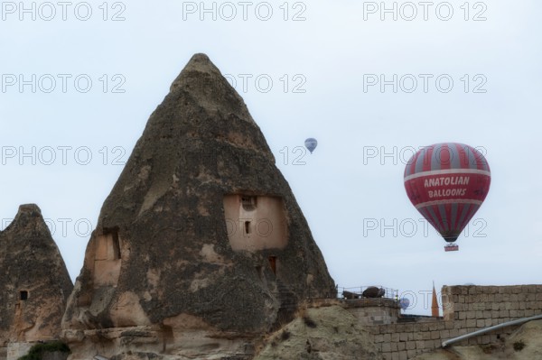 Goreme, Cappadocia, Turkey. October 13th 2018 Hot air balloons rise of traditional cone shaped rock