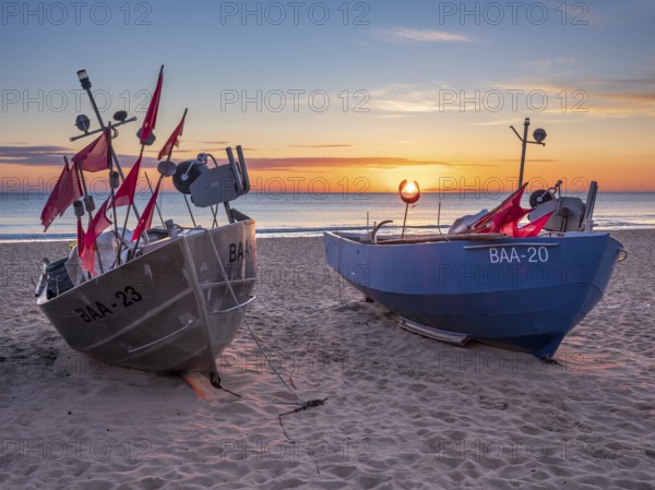 Fishing boats with red flags on fishing beach on the Baltic Sea at sunrise, Baabe, Mönchgut
