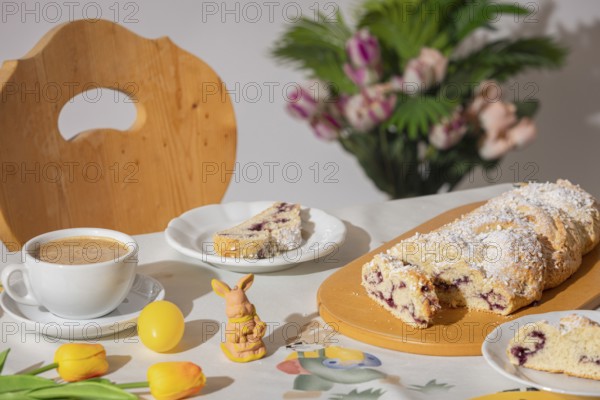 Breakfast table with coffee, sliced yeast braid and decoration for Easter