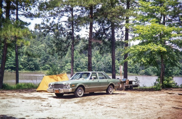 1976 Plymouth Volaré car automobile parked on campsite next to small two-man tent, USA 1976