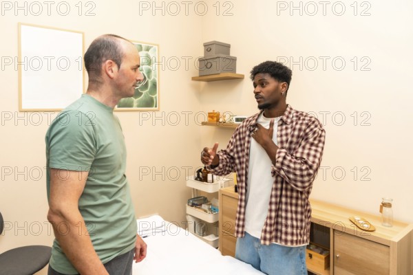 Two men in a counseling session engage in serious, supportive conversation in a clinical office,