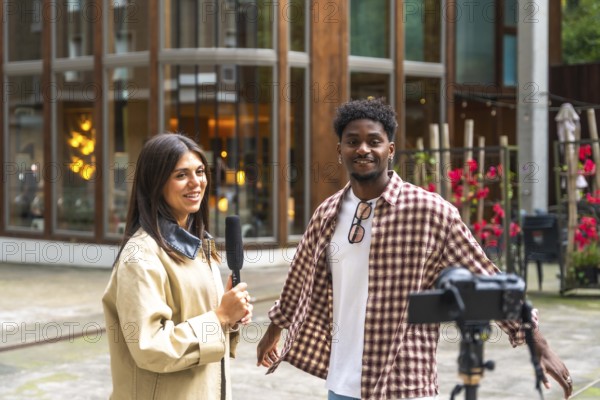 Journalist holding a microphone interviewing a young man on a city street, documenting the