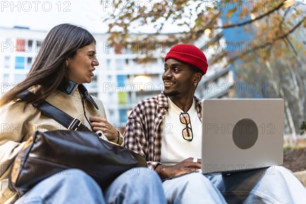 Diverse young students sitting outdoors in an urban environment, engaging in conversation and