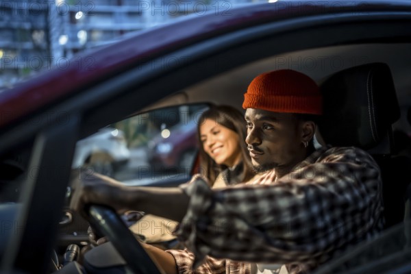 Young couple driving through city streets at night, enjoying a relaxed evening outing together
