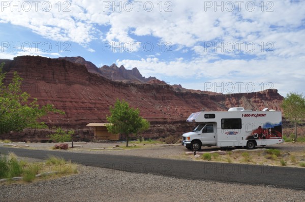 Motorhome standing in a rocky landscape with red rocks and partly cloudy sky, Grand Canyon National