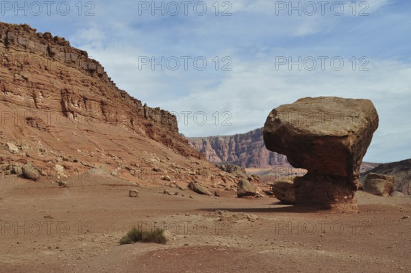 Huge single rock in a red desert landscape with cloudy sky, Grand Canyon National Park, Arizona,