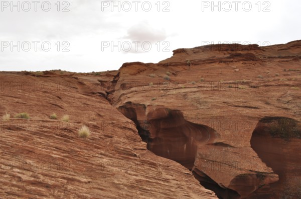 Wide rocky landscape with heavily eroded sandstone formations and a cloudy sky, Antelope Canyon,