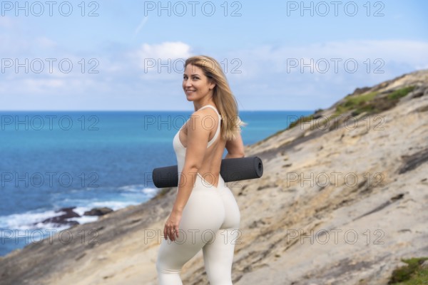Woman holding a yoga mat, ready to practice mindfulness and engage in a healthy lifestyle with