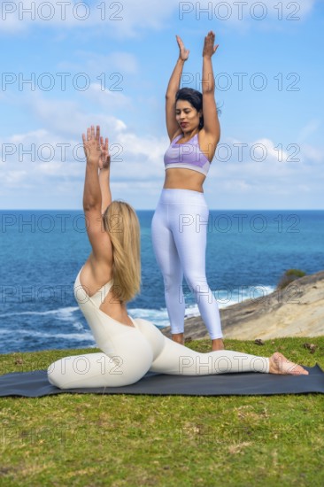 Women practicing yoga poses and meditation outdoors, an instructor guiding a student on a yoga mat