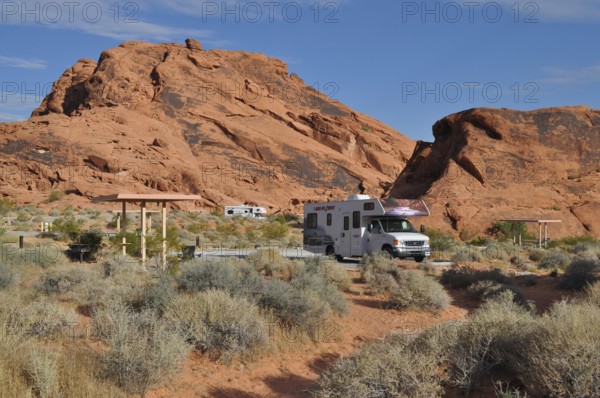 RV on campground in desert landscape with large red rocks and sparse vegetation, Valley of Fire