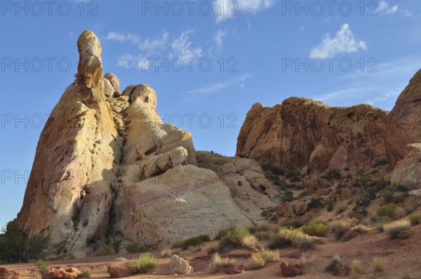 Dramatic sandstone cliffs rise into the sky under bright sunshine and blue skies, Valley of Fire