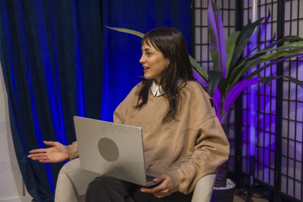 Woman presenting ideas from a modern content creation studio, smiling and gesturing while recording