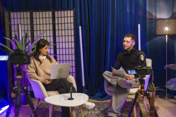 Content creators recording a video podcast or online interview in a broadcast studio, engaging with