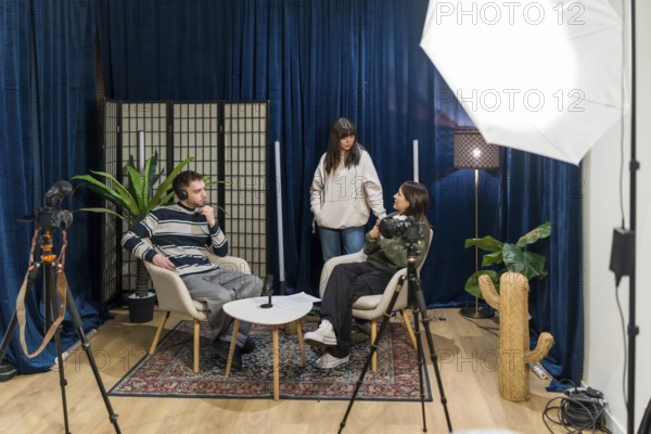 Content creators producing new social media video, with two people sitting and discussing while a