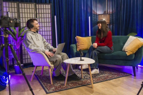 Diverse young content creators recording a podcast or social media video, sitting in a modern