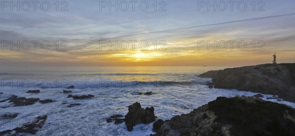 A lighthouse watches over the turbulent sea at sunset, the waves hit the rocks, hike the