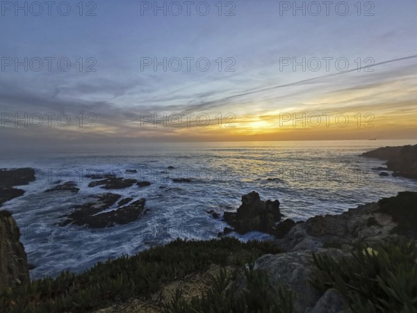A peaceful sunset over the moving sea with intense colors in the sky, hiking on the Fisherman's