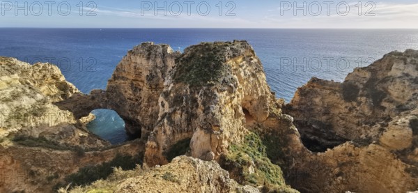 Archway, Dramatic rock formations overlooking the vast ocean under blue sky, Lagos, Algarve,