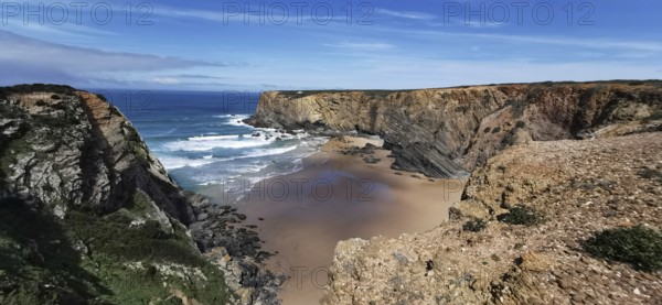 Wide sandy bay surrounded by rugged cliffs with gentle waves, hiking on the Fisherman's Trail,