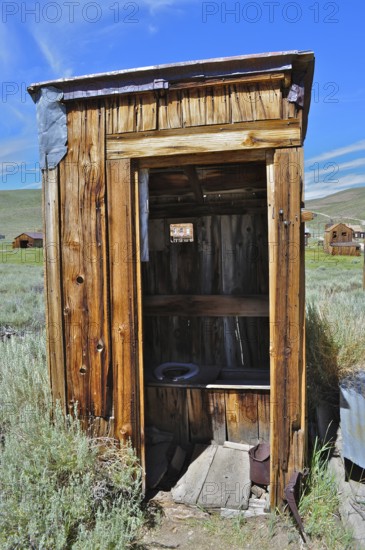 An old, rustic wooden cabin, toilet, outhouse, in historic construction in a rural area, Bodie