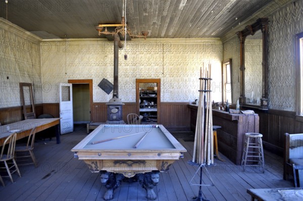 An abandoned billiard room in a saloon with antique rustic decor and wooden furniture, Bodie Ghost