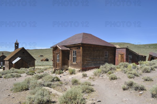 Abandoned wooden houses in the middle of a sandy and dry landscape, Bodie Ghost Town, California,