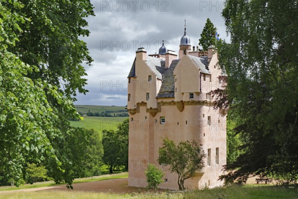 Pink castle surrounded by green countryside and trees, Craigievar Castle, Aberdeenshire, Scotland,