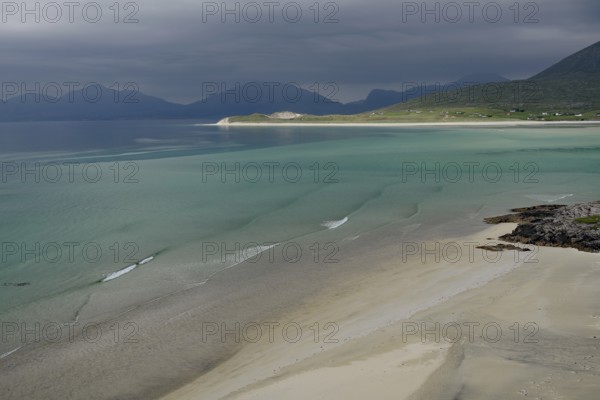 Wide sandy beaches under dark skies with calm seas and mountains, Outer Hebrides, Hebrides, Isle of