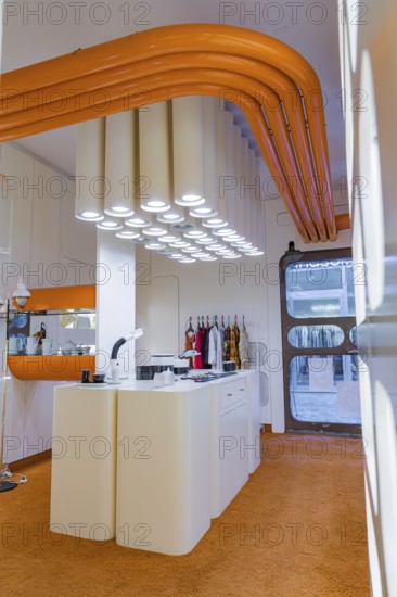 Contemporary kitchen with eye-catching white lighting and orange decoration