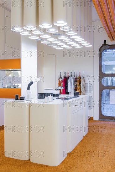 Modern kitchen with futuristic design and eye-catching lighting, orange carpet