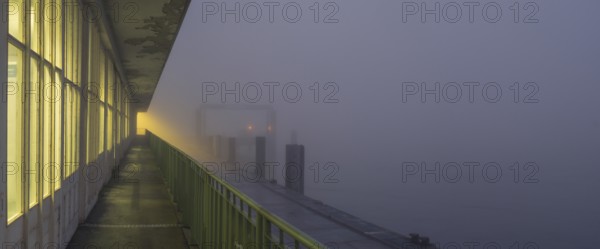 View along a long balcony of Steubenhöft of the ferry dock at Lübbenkai in fog, Cuxhaven, Lower